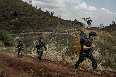 Min Thar (right), a former banquets and events worker at the Lotte Hotel in Yangon who joined the People's Defence Force (PDF), patrols with other PDF soldiers on the frontline close to Myanmar Army p...