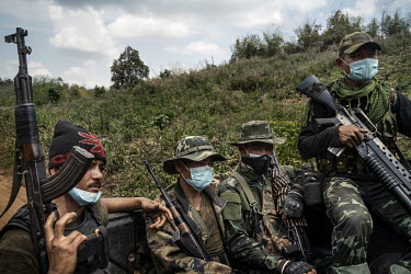 Members of the DKBF, a Karen ethnic armed group, keep a lookout as their travel in the back of a pickup truck near the frontlines with the Myanmar Army in an undisclosed location in Karen State.