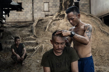 A soldier from the DKBF, a Karen ethnic armed group, has his head shaved by comrades on their base in an undisclosed location in Karen State.