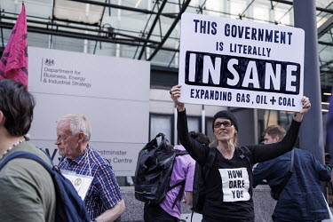 A woman holds a placard that reads: 'This Government is literally INSANE', during a protest in Westminster outside the Department for Business, Energy and Industrial Strategy (BEIS) against the licens...