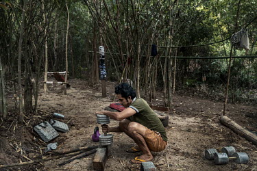 A People's Defence Force (PDF) soldier makes dumbbells in a jungle gym at a PDF camp in an undisclosed location in Karen State.