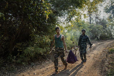 Soldiers from the KNLA, an ethnic armed group, carry a deer they hunted in the jungle back to the People's Defence Force base where they are based in an undisclosed location in Karen State.