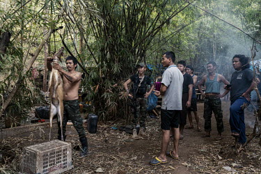 A soldier from the KNLA, an ethnic armed group, demonstrates to People's Defence Force (PDF) soldiers how to skin and butcher a deer that was hunted in the jungle, at a joint KNLA and PDF base in an u...