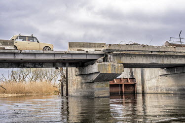 A vehicle passes over the destroyed Irpin dam and lock on the Kyiv reservoir. The cause of the current flooding is not clear with speculation that it was either an Ukrainian attempt to block Russian m...
