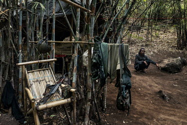 A soldier from the KNLA, a Karen ethnic armed group, squats beside some military equipment in a joint KNLA and People's Defense Force (PDF) base in an undisclosed location in Karen State.
