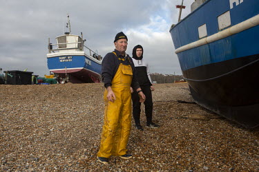 Fishermen Stuart Hamilton and Alfie White look out to sea after landing their catch on the shingle beach at Hastings.