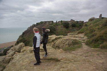 A couple look out to sea near Hastings Castle which sits high above the town.