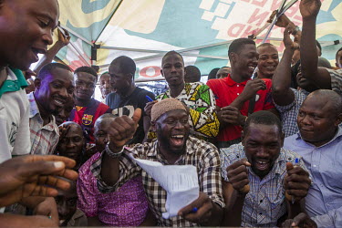 Men cheering as voting results indicate Muhammed Buhari is the winner of the presidential election.