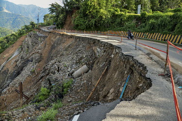 A stretch of road which has partly collapsed due to a landslide.