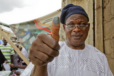 An elderly man shows an inked thumb before casting his vote as Nigeria goes out to vote for the presidential election.