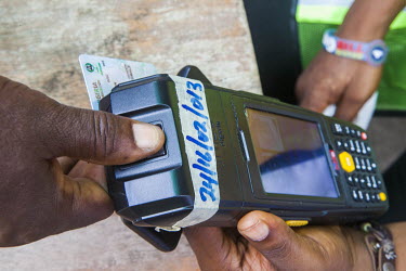 Voters have thumbprints scanned while using newly introduced biometric voter cards in the presidential election.
