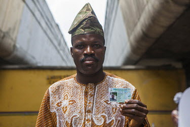 A man holds his biometric voter card, newly introduced for the presidential election in 2015.