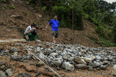Keuheuningle Jeme (left) and Pauheuchanhbe Jeme (right), the parents of Nchilungle Jeme (10), mourn at the place in Hoki Puonci village where their house once stood until it was destroyed by the lands...