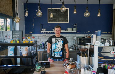Ruslan, owner of Jul's Coffee and Wine, stands at the counter of his cafe which he opened just two weeks ago. Ruslan does not live in Bucha, but when they occupied the town his customers took the equi...