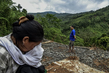 Keuheuningle Jeme (left) and Pauheuchanhbe Jeme (right), the parents of Nchilungle Jeme (10), mourn at the place in Hoki Puonci village where their house once stood until it was destroyed by the lands...