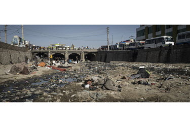 Drug addicted men lie among the detritus on the river bed near the Pul-e-Sukhta bridge (Pul-i-Sokhta) where, one estimate claimed, up to 1000 drug users regularly gather.