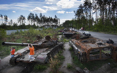 On a road near Bucha, destroyed Russian tanks from the area provide a curiosity for children and local walkers, while they wait to be removed.