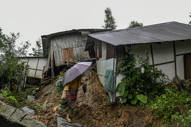 A resident tries to salvage possessions as she examines damage to her house in Gilgal village near Moulhoi which was destroyed by a landslide.