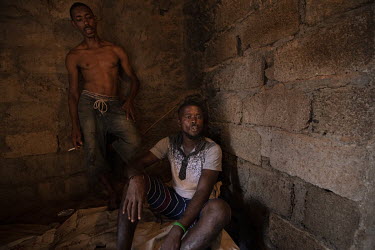 Matteo Rodrigues (35, standing) and Nathaniel Tavares (31), after smoking crack cocaine in a crack den in the neighbourhood of Ponta De Agua, Praia.  The Cape Verde islands lie on what's known as 'Hig...