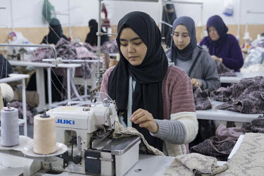 Uygur women use sewing machines while working in a textile company in Zeytinburnu.