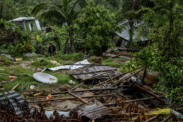 A resident tries to salvage possessions as he examines damage to his house in Gilgal village near Moulhoi which was destroyed by a landslide.