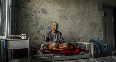 A patient undergoing rehab treatment at the Ibn Sina drug addiction hospital sits on a bed in one of the facility's dormitories.
