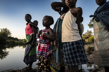 Women and children standing on the banks of the Maramba River which contains the parasite causing schistosomiasis (bilharzia).  Female Genital Schistosomiasis (FGS) is a waterborne parasitic disease a...