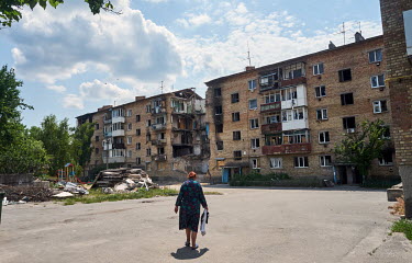 Oxana walks to her apartment building on Sadova Street in Gorenka, a small village on the outskirts of Kyiv, which was shelled by Russian forces during the attack on the capital. Her three room apartm...