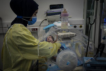 A member of the medical staff examines a baby being treated in an incubator in the neo-natal intensive care unit at Karantina Public Hospital. The hospital has only a few days of diesel in reserve. If...