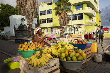 A woman selling fruit from a street stall.