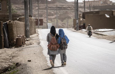 Two young girls holding hands as they walk to school. Under the new Taliban regime they will not be able to attend secondary school. New Taliban rules decree that women must cover their faces. If a wo...