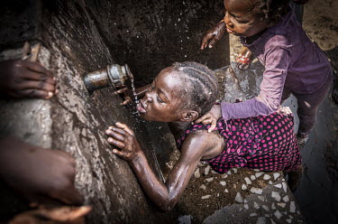 A girl drinks clean water, which she has paid for, at a standpipe in Kanyama compound (population 400,000).Female Genital Schistosomiasis (FGS) is a waterborne parasitic disease affecting women. Sympt...