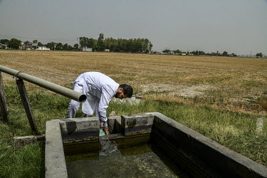Surmakh Singh stands beside an water trough on his farm in his village in the Punjab.
