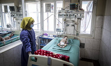 A nurse watches over a baby in the intensive care unit at the Indira Ghandi Children's Hospital.