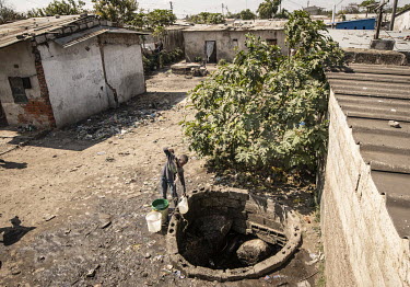 A boy pulls up a container of water from an open well in the Kanyama Compound (population 400,000). When the area floods, sewage seeps down into the well.  Female Genital Schistosomiasis (FGS) is a wa...