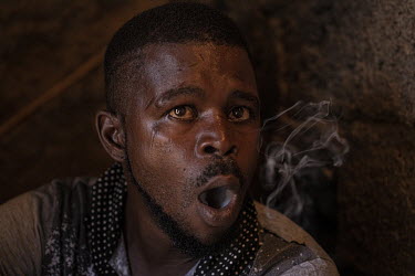 Nathaniel Tavares (31) exhales while smoking crack cocaine in a crack den in the neighbourhood of Ponta De Agua, Praia.  The Cape Verde islands lie on what's known as 'Highway 10', the DEA's nickname...