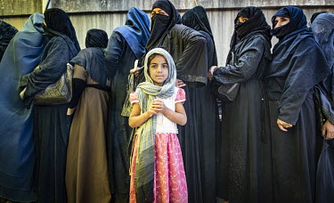 Reyhana stands in a queue of women at a World Food Programme (WFP) distribution centre near Madina Bazaar in central Kabul.