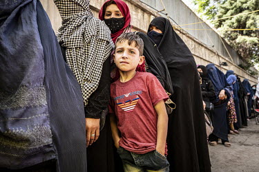 Muzamel (8) stands in a queue of women at a World Food Programme (WFP) distribution centre near Madina Bazaar in central Kabul.