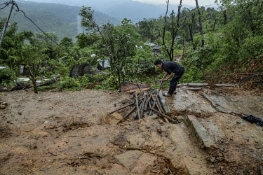 A resident tries to salvage material as he examines damage to his house in Gilgal village near Moulhoi which was destroyed by a landslide.