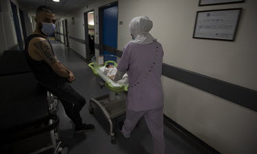 A nurse movesa baby in the maternity ward at the Rafic Hariri Hospital.  Following political collapse and the pandemic, the Lebanese economy plunged, wiping out 90% of people's savings and resulting i...