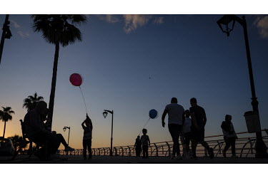 Children play with balloons on Beirut's fashionable, and now unlit, corniche which has become the only place many can afford to visit for recreation in the city. The national grid is now providing onl...