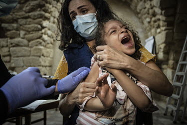 Six year old Maria Hachem cries as she receives an MMR vaccine at the Medair supported Natacha Saad popular clinic in Saida.  Following political collapse and the pandemic, the Lebanese economy plunge...