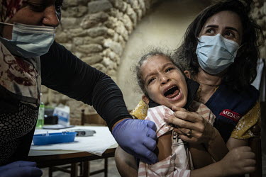 Six year old Maria Hachem cries as she receives an MMR vaccine at the Medair supported Natacha Saad popular clinic in Saida.  Following political collapse and the pandemic, the Lebanese economy plunge...