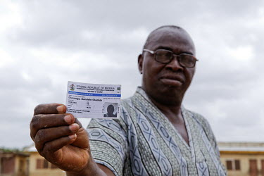 Bamidele, 66, shows his voter's registration card. He is one of the many Nigerians that was barred from voting in the recent presidential election because their names were ommitted from the Independen...