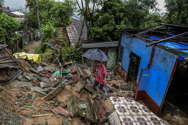 A resident examines damage to his house, in Gilgal village near Moulhoi, which was destroyed by a landslide.