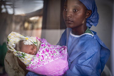 An ebola survivor, who has a level of immunity, cares for an 8-day-old baby girl called Felicite (not her real name) in the intensive care section of an ebola trearment centre. Shortly after the Felic...