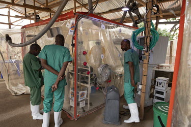 Medical staff check on a patient in an isolation cube at the Beni Ebola Treatment Centre.
