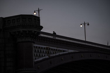 A man crosses Blackfriars Bridge at sunset during the coronavirus lockdown.