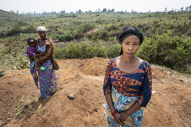Dosabi Umani (38, L) with her baby Hepe (1) and Chantal Safari (39), the two wives of Jonathan Mandevu, stand at his graveside at Tsere IDP camp. Jonathan was hacked to death by an ethnic militia when...