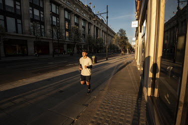 A man runs along Oxford Street at sunset during the coronavirus lockdown.